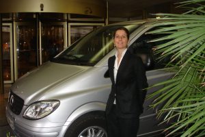 Une femme conductrice devant le Mercure Centre bourse à Marseille pour un transfert vers l'aéroport de Marseille-Provence